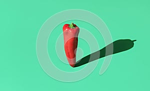 Sweet red pepper in bright light minimalist on a green background