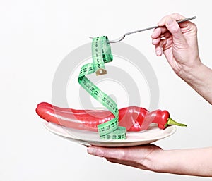 Sweet red pepper on a plate with tape measure and fork
