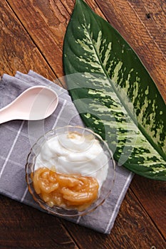 Sweet Rice Noodles with Coconut Cream served in a glass cup on a brown wooden table