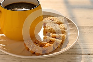 Sweet rice puffs blocks & fried dough twists and peanut brittles and cup of coffee on a dish