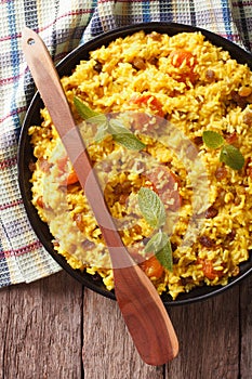 Sweet rice with saffron and dried fruits close-up. vertical top