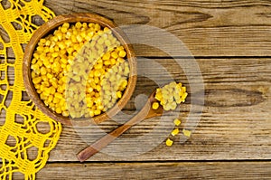 Sweet ripe canned corn in wooden bowl