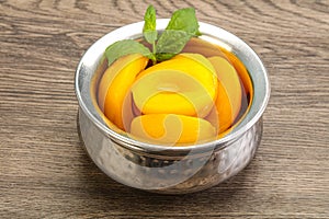 Sweet ripe canned peaches with mint