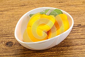 Sweet ripe canned peaches with mint