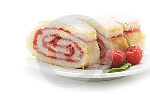 Sweet roll cake with raspberry jam and berries, isolated on a white