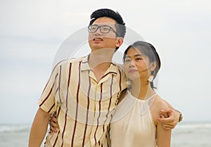 Sweet and romantic lifestyle portrait of young happy Asian Chinese couple in love enjoying holiday on beautiful beach walking