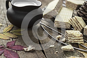 Sweet russian artek waffles on wooden background, with a pot of milk. Traditional sweets and dessert