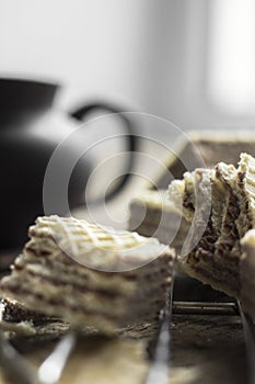 Sweet russian artek waffles on wooden background, with a pot of milk. Traditional sweets and dessert