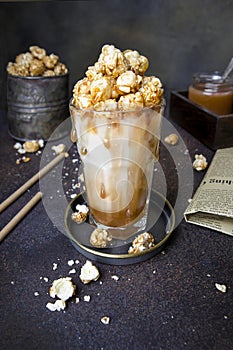 Sweet and salty caramel popcorn milkshake, caramel, milk, vintage dark background, drink