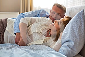 Sweet senior couple cuddling in bed