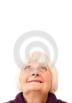 Sweet senior woman looking up at copyspace