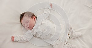 Sweet, sleeping and newborn baby on a bed at a home in the bedroom for resting and dreaming. Cute, tired and top view of