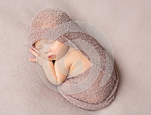 Sweet sleeping newborn girl covered with shawl