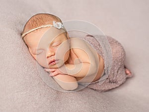 Sweet sleeping newborn girl covered with shawl