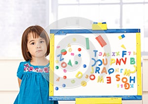 Sweet small girl standing at drawing board