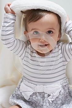 Sweet, smile and portrait of baby with a blanket for playing, sitting and having fun at home. Happy, excited and face of