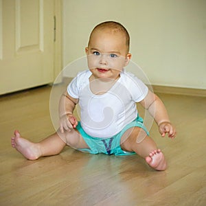 Sweet smiling baby on the floor. Baby boy at home