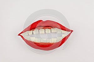 Sweet smiling mouth, model from clay Lips and gums were cut from colored clay, teeth of cubes of refined sugar