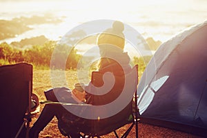 Sweet solitude as the sun rises. Rear view of a young woman sitting in a camping chair and enjoying the scenery.