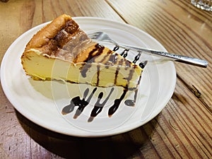 Sweet and sour cheesecake topped with chocolate sauce