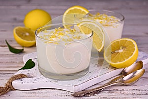 Sweet and sour creamy lemon dessert in a glass on a white background.