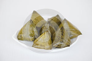 Sweet stuffed dough pyramid or Khanom Tian in Thai language, wrapped by banana leaf and streamed.