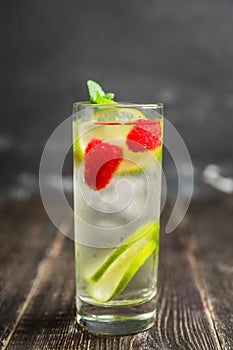 Sweet summer cocktail with raspberry and lime on the rustic background
