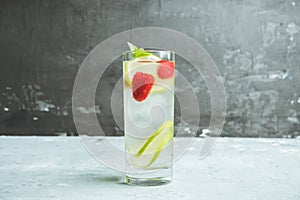 Sweet summer cocktail with raspberry and lime on the rustic background