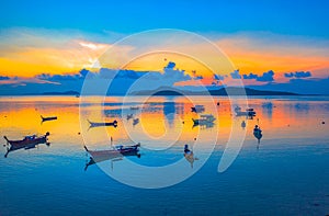 Sweet sunrise above fishing boats on the beach.