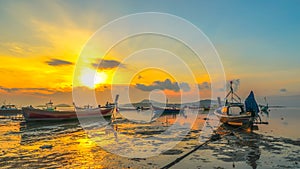 Sweet sunrise above fishing boats on the beach.