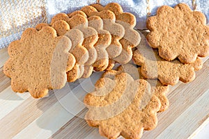 Sweet Swedish almond thins with ginger and cinnamon (Pepparkaka or Pepparkakor biscuits) on light wooden background.