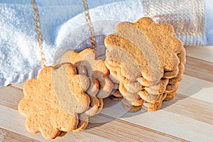 Sweet Swedish almond thins with ginger and cinnamon (Pepparkaka or Pepparkakor biscuits) on light wooden background.