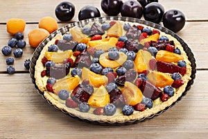 Sweet tart with peaches, plums and blueberries photo