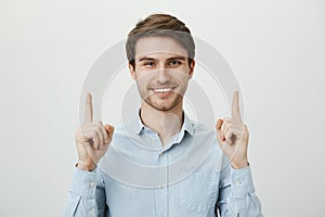 Sweet taste of victory. Portrait of handsome bearded caucasian guy with confident and broad smile standing in ordinary