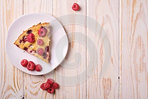 Sweet tasty pie slice with jellied and fresh raspberry fruits in plate, wooden table background