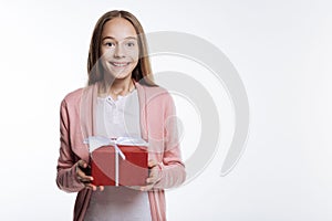 Sweet teenage girl holding a gift box