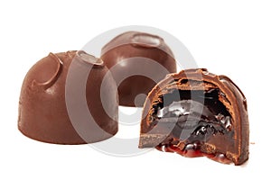 Sweet temptation conceptual idea with chocolate covered cherries or cordials isolated on white background