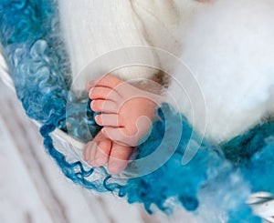 Sweet tiny newborn feet on fluffy blanket