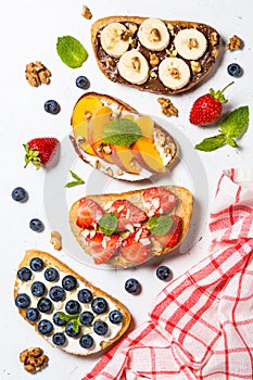 Sweet toast assortment with fresh fruit and berries on white.