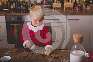 Sweet toddler child, boy, helping mommy preparing Christmas cook