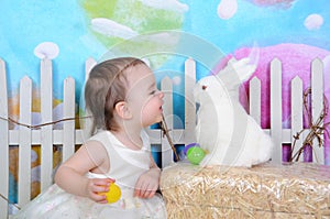 Sweet toddler girl with bunny at easter