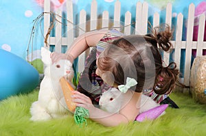 Sweet toddler girl feeding bunny at easter