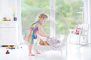 Sweet toddler girl playing with her teddy bear