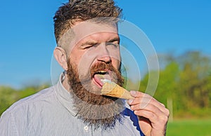 Sweet tooth concept. Bearded man with ice cream cone. Man with long beard licks ice cream. Man with beard and mustache