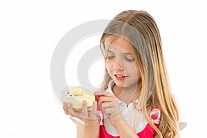 Sweet treasure. Girl calm face carefully holds sweet donut in hand, isolated white. Kid girl with long hair likes donuts