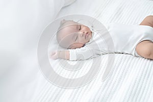 Sweet two month old newborn baby boy sleep on white sheet bed,asian little baby napping in bed at home