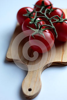 Sweet vine ripened tomatoes on wooden board