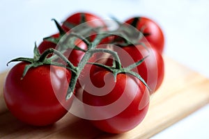 Sweet vine ripened tomatoes on wooden board