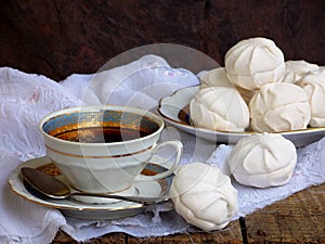 Sweet white Russian marshmallow, chocolate zephyr, meringue and cup of coffee on wooden background.