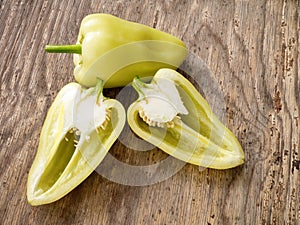 Sweet yellow bulgarian pepper, cut. Isolated on wooden table